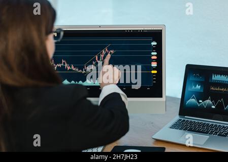 Crop woman analyzing graph on binary option Stock Photo