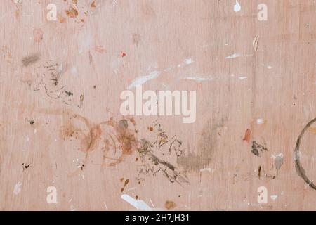 Colorful paint splashes on wooden board. Flat lay, top view. Abstract background from a painter workshop. White, brown and grey colors on plywood Stock Photo