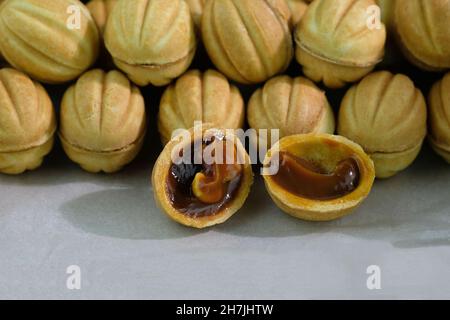 Cookies with condensed milk and walnuts in the middle. Cookies in the form of nuts with a filling. Homemade cakes with boiled condensed milk. Deliciou Stock Photo