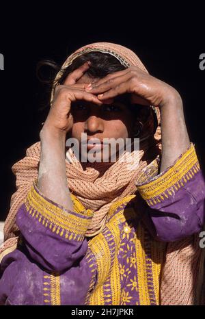 A Baluch girl sits at the doorstep of their mud home, at the village of Sultan Koth, in Sibi district of the Beluchistan province in Pakistan. The Sib Stock Photo