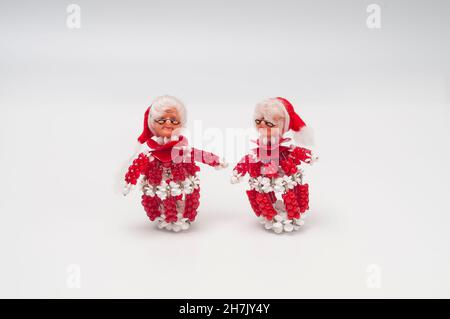Two miniature Mrs. Clauses made from red beads and safety pins. Stock Photo