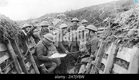 WW1 BRITISH SOLDIERS. Reading a document - possibly a map - in the trenches. Location and unit not known.