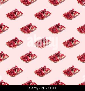 Bright red pomergranate pieces repeat seamless pattern on light pink background. Stock Photo