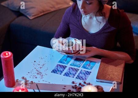 Fortune-teller concentrated on interpreting symbols in coffee grounds Stock Photo