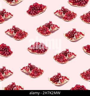 Bright red pomergranate pieces repeat seamless pattern on light pink background. Stock Photo