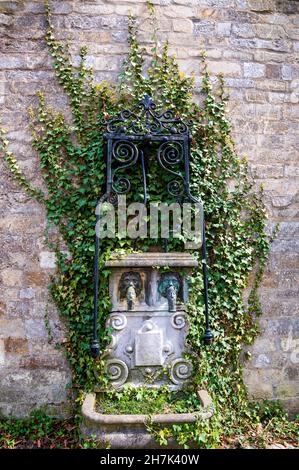 Small fountain decorated with foliage by the wall, Kasteel van Groot-Bijgaarden, Belgium Stock Photo