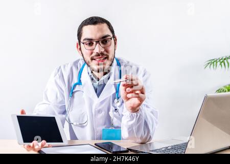 Bearded doctor with optical glasses sitting in his room and talking about a medical topic Stock Photo