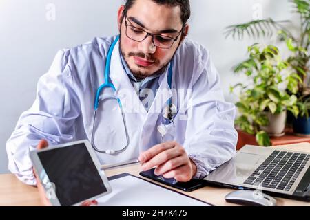 Bearded doctor with optical glasses sitting in his room and talking about a medical topic Stock Photo