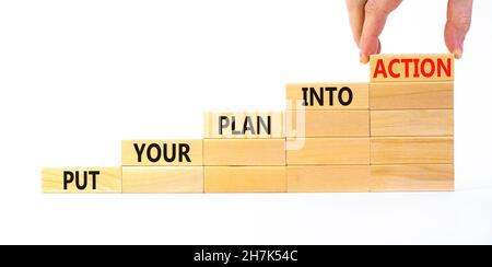 Put your plan into action symbol. Wooden blocks with words Put your plan into action. Beautiful white background, copy space. Businessman hand. Busine Stock Photo