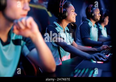Young woman with headphones plays computer game in internet club Stock Photo