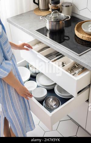 Top view modern housewife tidying up kitchen cupboard during general cleaning or tidying up Stock Photo