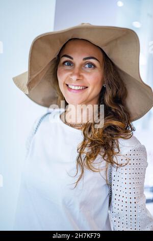 Closeup overjoyed young brunette female shopaholic wearing fashion hat having positive emotion Stock Photo
