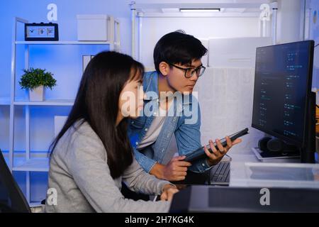 Programmer and developer teamwork working in a software development and coding technologies at night. Stock Photo