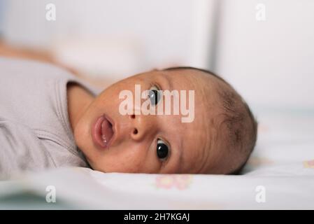 Portrait of newborn baby lying in bed. Stock Photo
