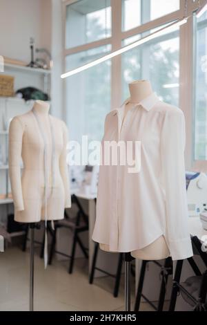 White handmade sewing shirt on dummy at studio sew workshop. Fashion dressmaker or seamstress Stock Photo