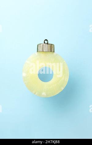 christmas bauble decoration made of pineapple on blue background. Minimal New year concept. Close up Stock Photo