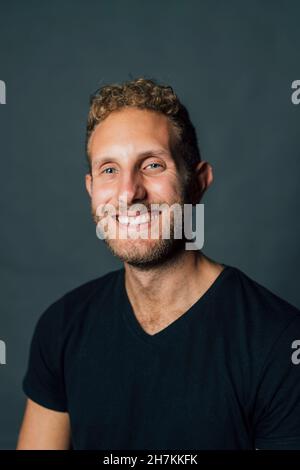 Happy young man against gray background Stock Photo