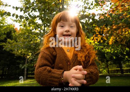 Smiling girl with down syndrome in park Stock Photo