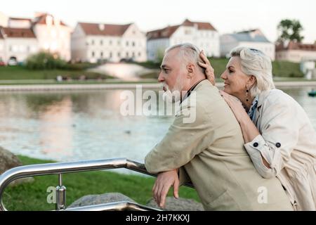 Smiling woman leaning on man at railing Stock Photo