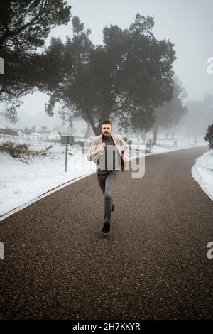 Man wearing blazer running on road Stock Photo