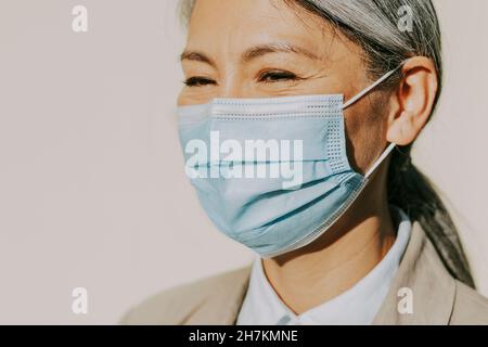 Mature woman wearing protective face mask during pandemic Stock Photo