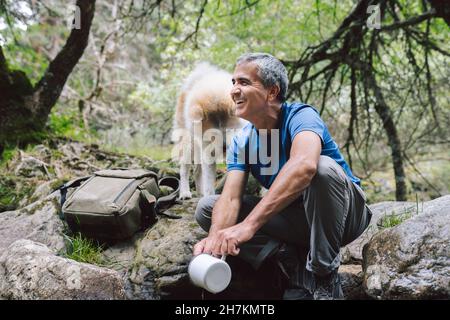 Smiling man using virtual reality simulator in forest Stock Photo