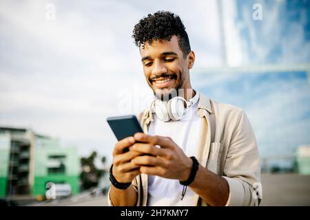 Happy man with headphones using smart phone Stock Photo