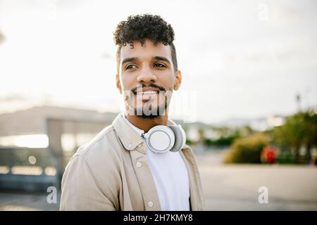 Young bearded man with black hair wearing wireless headphones Stock Photo
