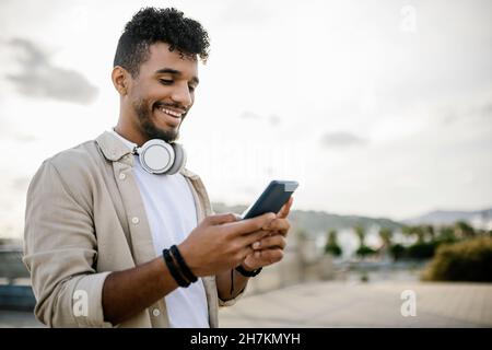 Happy man with wireless headphones using smart phone Stock Photo