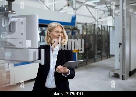 Female professional working on digital tablet at factory Stock Photo