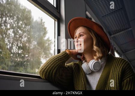 Woman looking through window while travelling in train Stock Photo