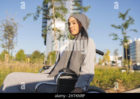 Happy young female professionals standing back to back by yellow wall Stock Photo