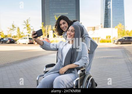 Cheerful female professionals gesturing while sitting on bench Stock Photo
