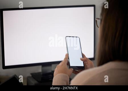 Female freelancer using mobile phone while working at home Stock Photo