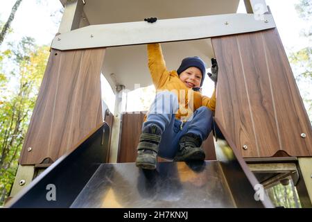 Man drinking iced coffee by son on bench Stock Photo