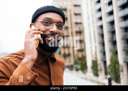 Smiling bearded man talking on smart phone Stock Photo