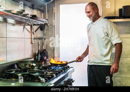 Smiling male chef cooking in restaurant Stock Photo