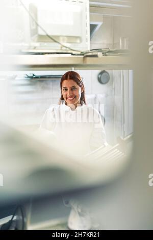 Smiling female chef in kitchen at restaurant Stock Photo