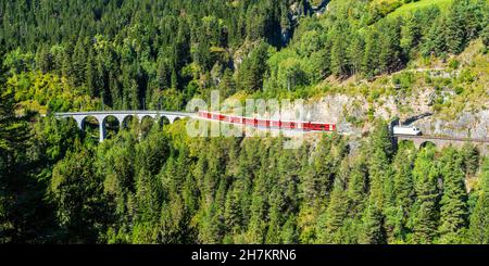 Switzerland, Graubunden Canton, Train crossing Landwasser Viaduct in summer Stock Photo