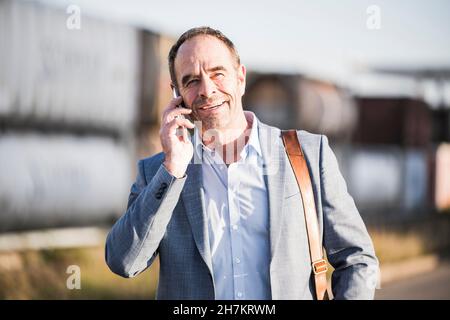Smiling businessman talking over mobile phone Stock Photo