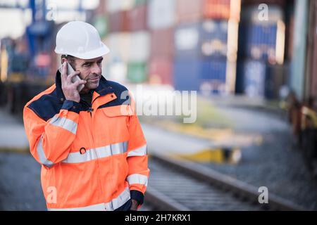 Male worker talking on smart phone at dock Stock Photo