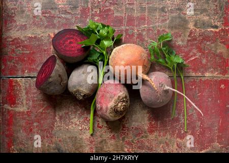 Raw beetroots and parsley on weathered wooden surface Stock Photo