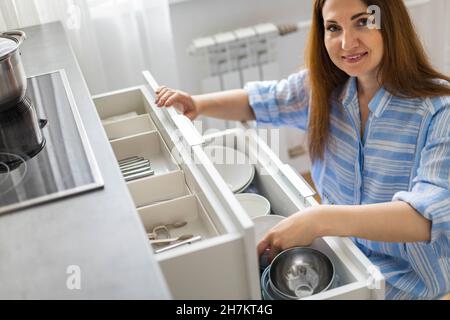 Top view modern housewife tidying up kitchen cupboard during general cleaning or tidying up Stock Photo