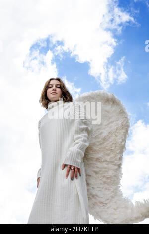Teenage angel wearing white wings Stock Photo