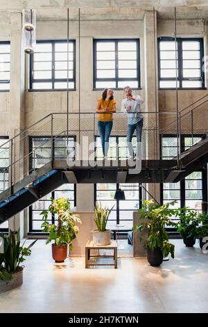 Coworkers having discussion at office staircase Stock Photo