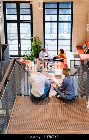 Young coworkers having discussion on office staircase Stock Photo