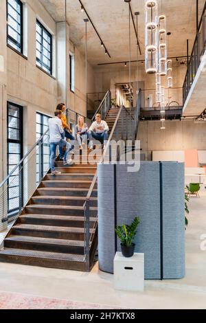 Coworkers having discussion on staircase in office Stock Photo