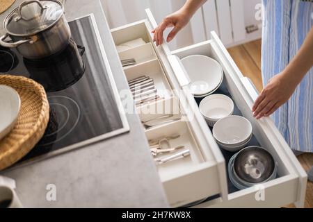 Top view modern housewife tidying up kitchen cupboard during general cleaning or tidying up Stock Photo