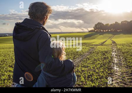 Girl looking out of window by father in train Stock Photo