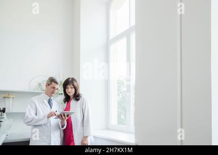 Scientist team using digital tablet in laboratory Stock Photo